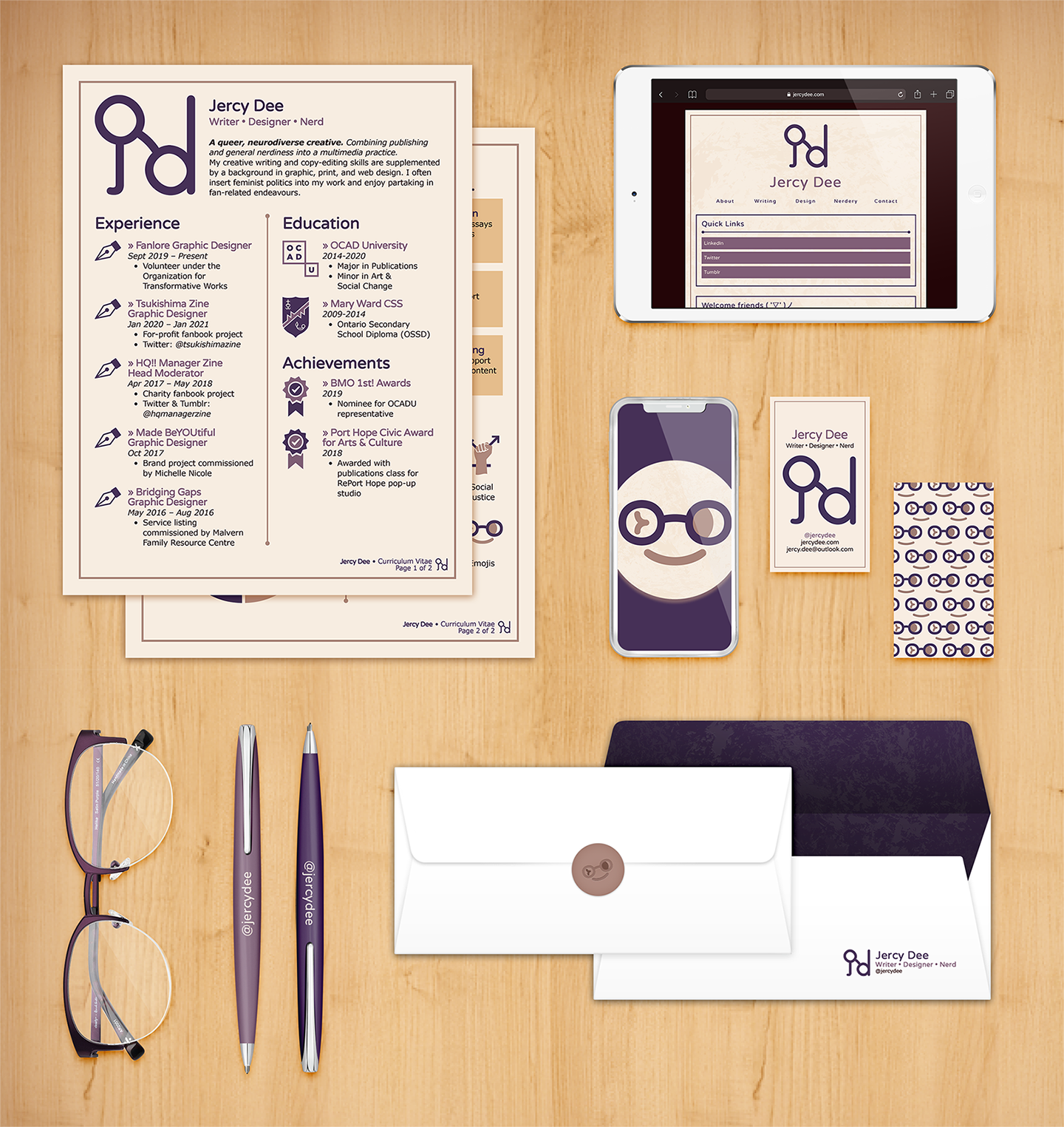 My brand applied onto different materials (CV, website on a tablet and mobile phone, business cards, pens, and envelopes) alongside my glasses against a wood background.