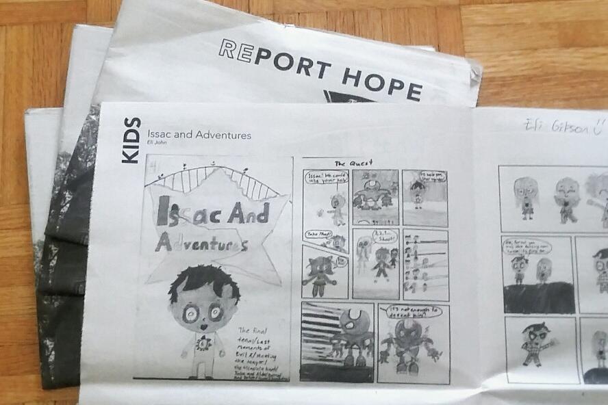 A printed copy of the RePort Hope newspaper opened to the Kids section.